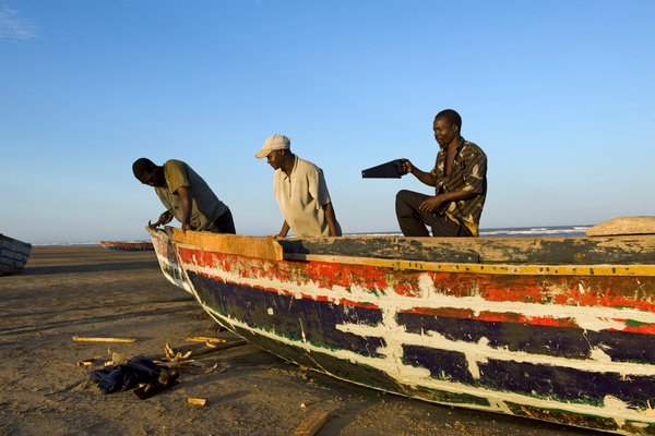  Fishermen repairing their boat on the beach north of Quelimane,Mozambique. globserver.cn